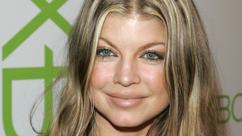 Fergie smiling with long blonde highlights