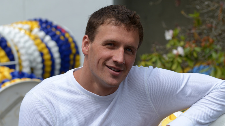 Ryan Lochte posing poolside in front of lane dividers