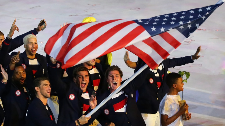 Team USA Swimming walking and holding a flag