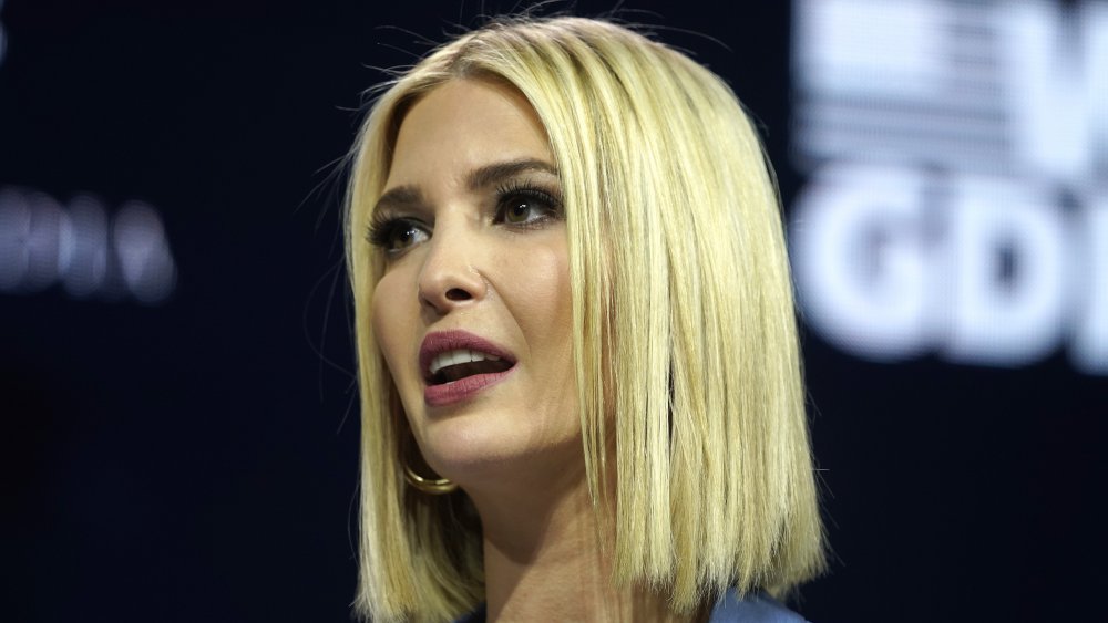 Ivanka Trump in a blue button-up, speaking on stage