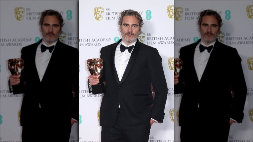 Joaquin Phoenix holding his BAFTA award in 2020