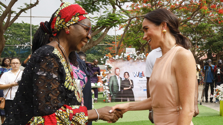 Meghan Markle shaking hands with a woman in Nigeria
