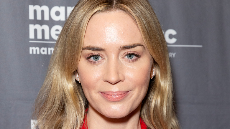 Emily Blunt smiles wearing diamond hoops