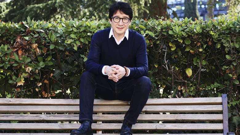 Ke Huy Quan sitting on bench