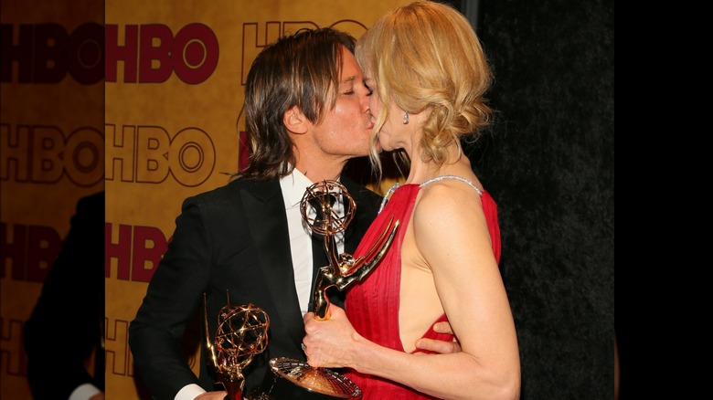 Keith Urban kissing Nicole Kidman holding Emmy Awards