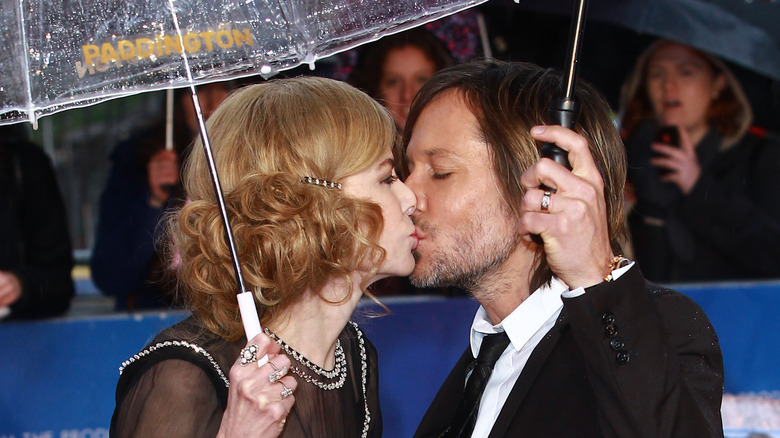 Nicole Kidman kissing Keith Urban under rain umbrella