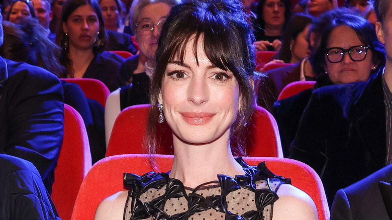 Anne Hathaway sitting and smiling