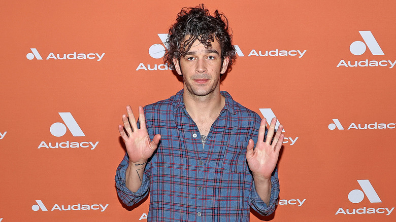 Matt Healy with his hands up