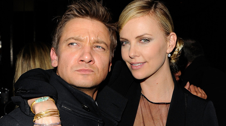 Charlize Theron with arm around Jeremy Renner