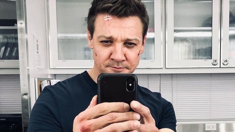 Jeremy Renner holding up phone