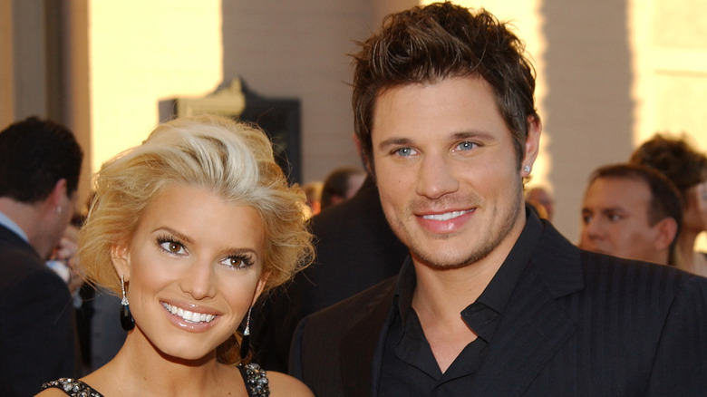 Jessica Simpson and Nick Lachey smiling on the red carpet