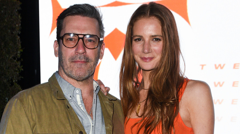 Jon Hamm in glasses and Anna Osceola in an orange dress