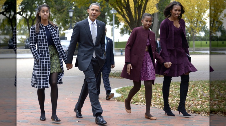 The Obama family holding hands, walking