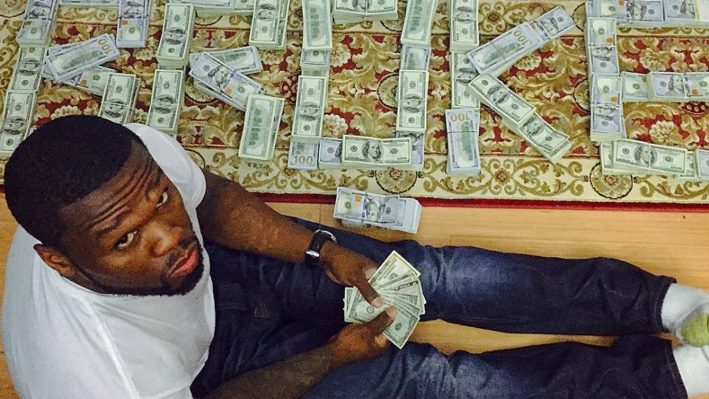 50 Cent posing with his fake cash