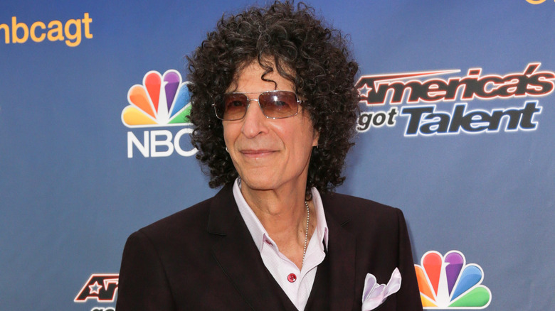 Howard Stern black suit curly hair