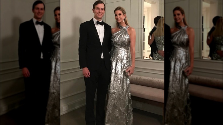 Jared Kushner wearing a tuxedo posing beside Ivanka Trump wearing a silver dress