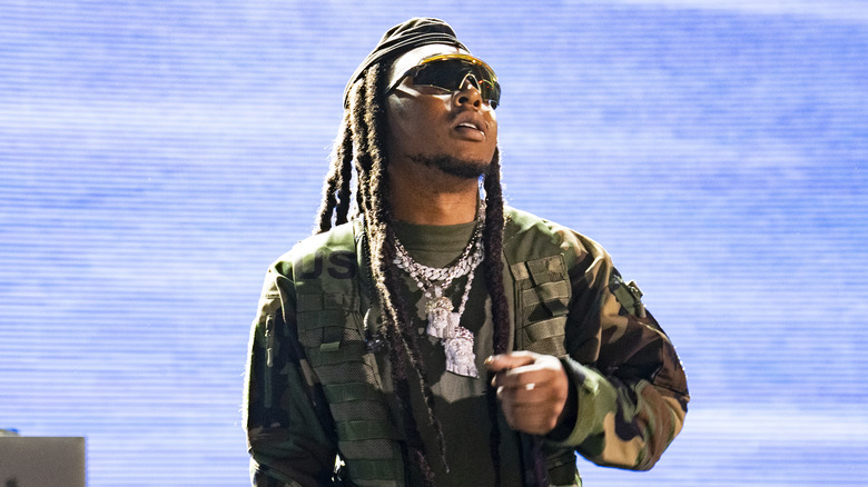 Takeoff in camo outfit, on stage performing