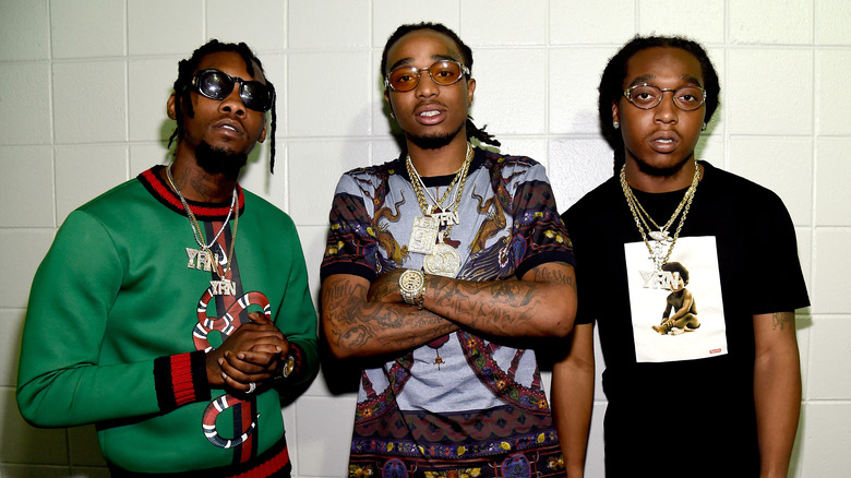 Migos wearing jewelry, posing together