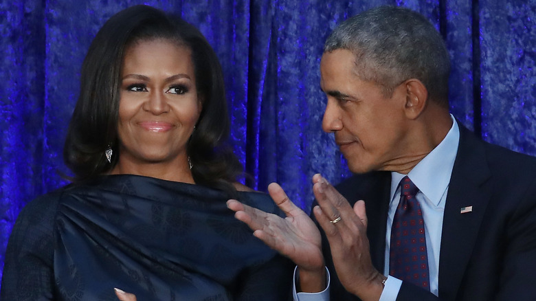 Michelle smiles while Barack claps