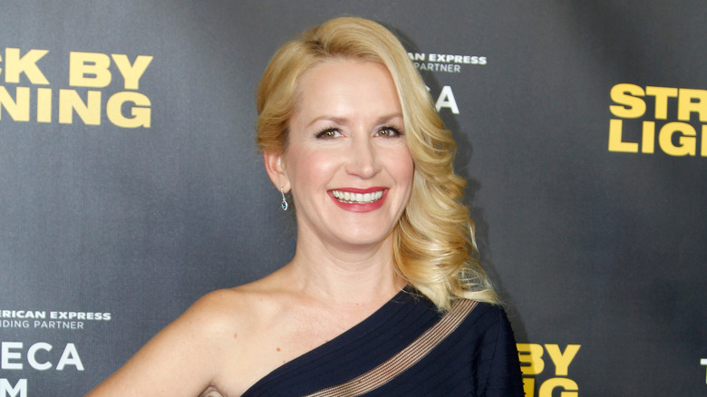 Angela Kinsey with curled hair smiling