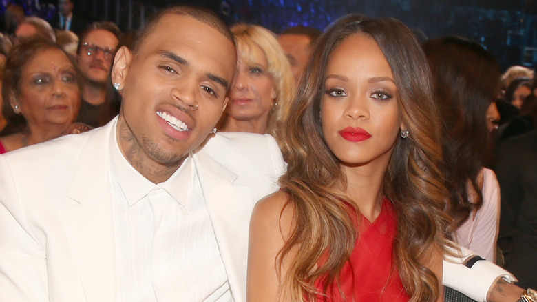 Chris Brown and Rihanna seated and smiling