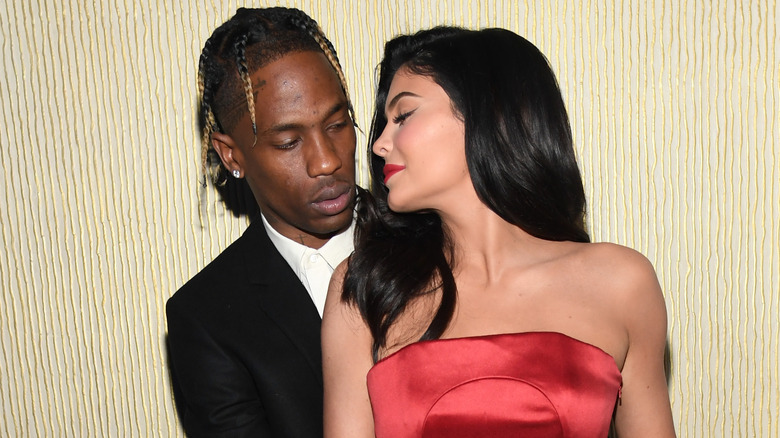 Travis Scott and Kylie Jenner at an event, looking at each other