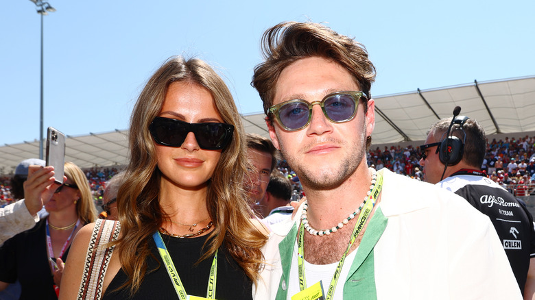 Niall Horan and Amelia Woolley stand together in sunglasses