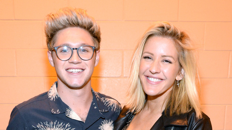 Niall Horan and Ellie Goulding stand together smiling