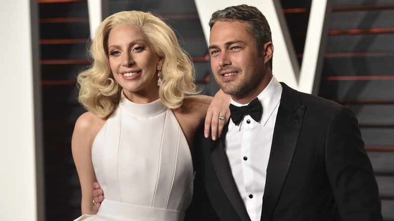 Lady Gaga wearing a white haulter gown and diamond ring with Taylor Kinney wearing a tuxedo and bowtie