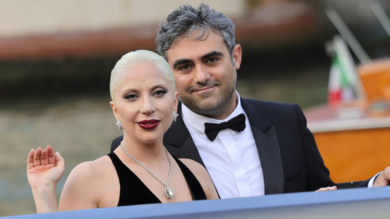 Lady Gaga wearing a black halter gown and diamond necklace with Michael Polansky wearing a black tuxedo