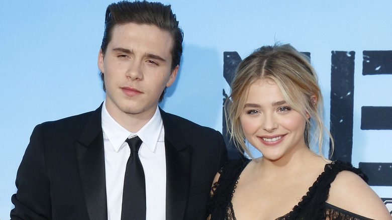 Chloë Moretz and Brooklyn Beckham by a blue wall