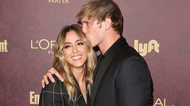 Chloe Bennet, smiling, getting kissed by Logan Paul in 2018