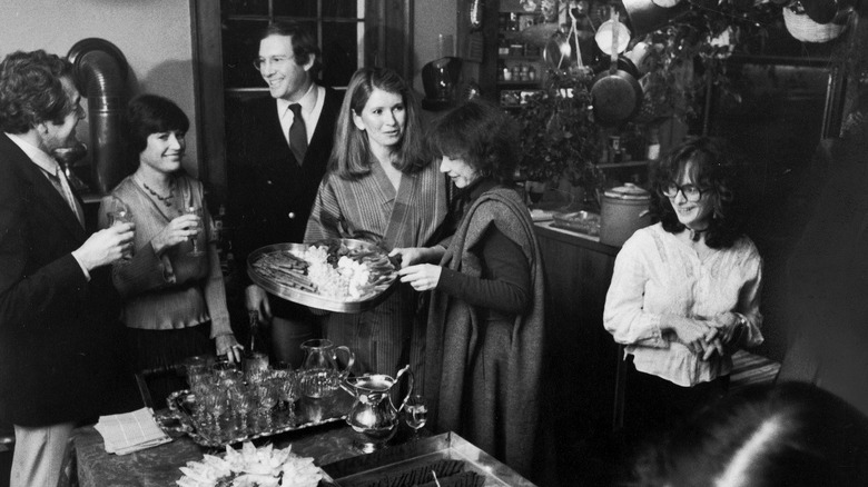 Andrew Stewart and Martha Stewart surrounded by dinner party guests.