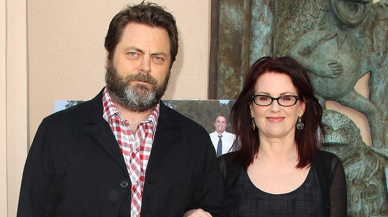 Nick Offerman and Megan Mullally posing arm-in-arm