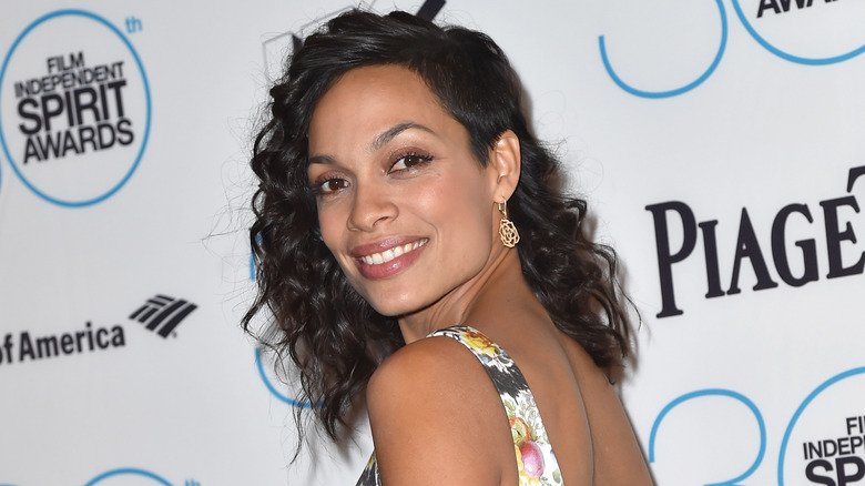 Rosario Dawson smiling over shoulder