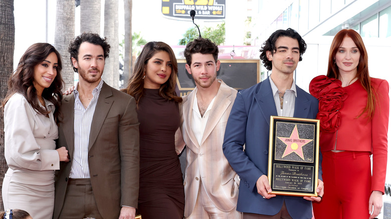 Sophie Turner posing with The Jonas Brothers