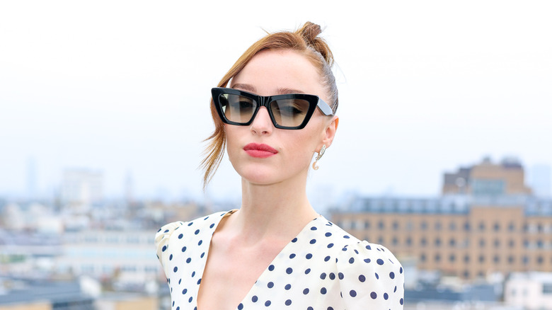 Phoebe Dynevor on a balcony in sunglasses