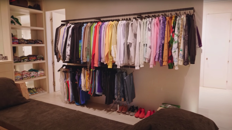 Adam Levine's closet with hanging shirts and daybed