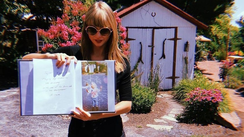 Taylor Swift posing in front of her childhood home