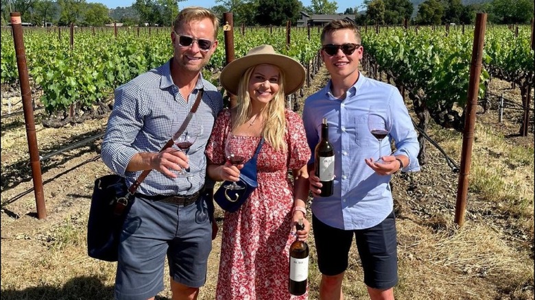 Valeri Bure, Candace Cameron Bure, and Lev Bure holding bottles and glasses of Bure Family Wines