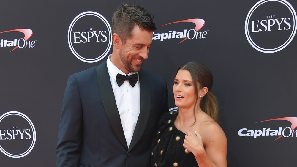 Aaron Rodgers smiling with Danica Patrick