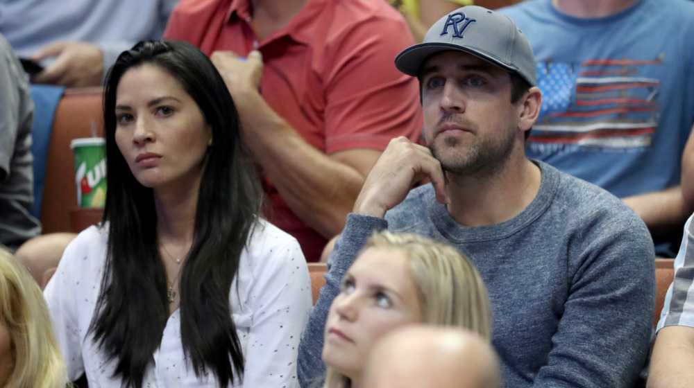 Olivia Munn and Aaron Rodgers sitting together in the stands