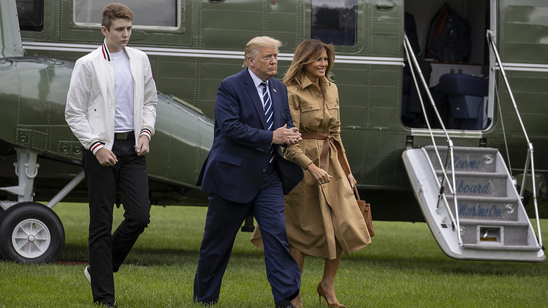 Barron Trump frowning behind parents