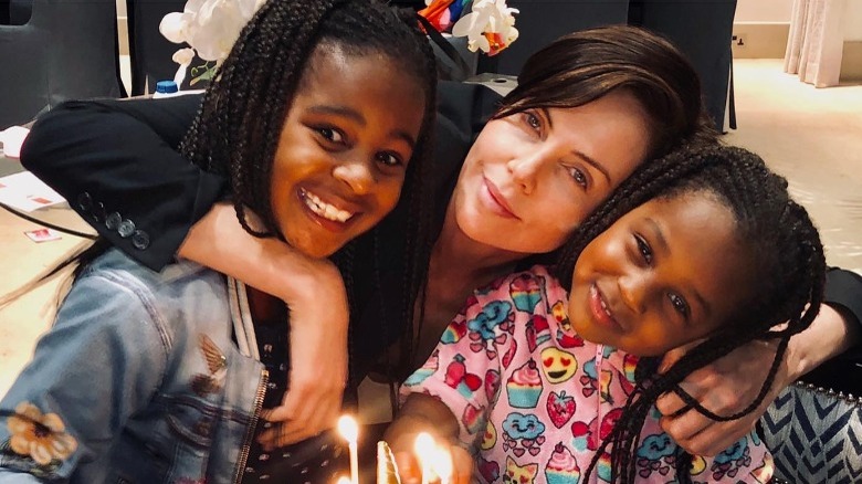 Charlize Theron and her daughters, smiling