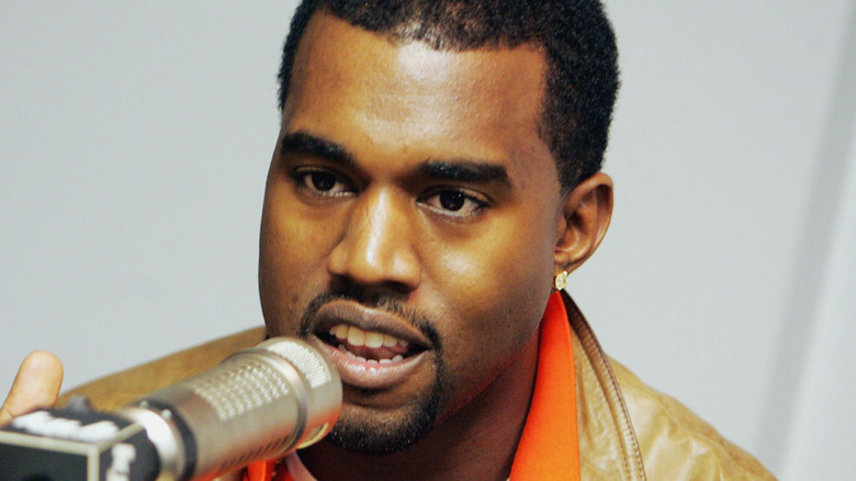 Kanye West speaking into a microphone 