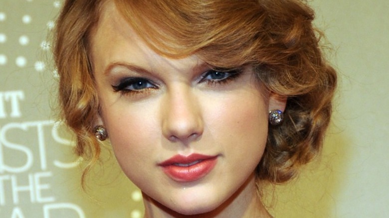 Taylor Swift smiling slightly with hair up