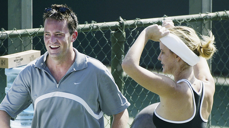 Matthew Perry and Maeve Quinlan smiling on tennis court