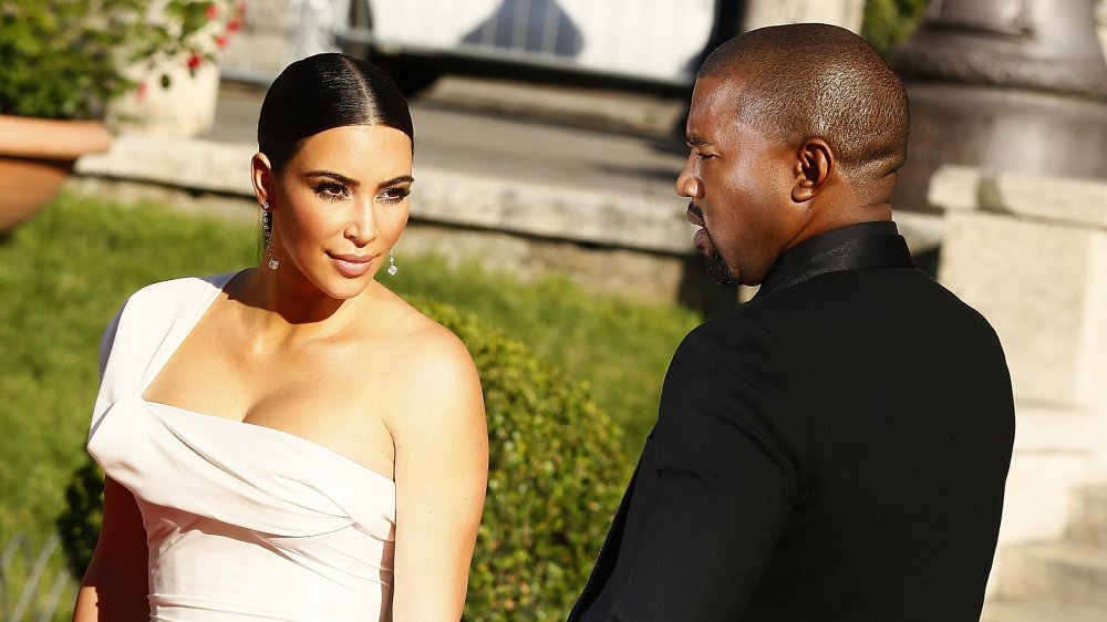 Kim Kardashian in a white dress and Kanye West at a red carpet event
