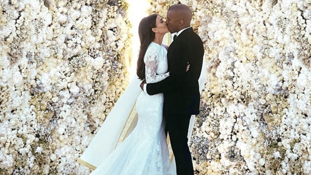 Kim Kardashian and Kanye West wedding ceremony in front of flower wall