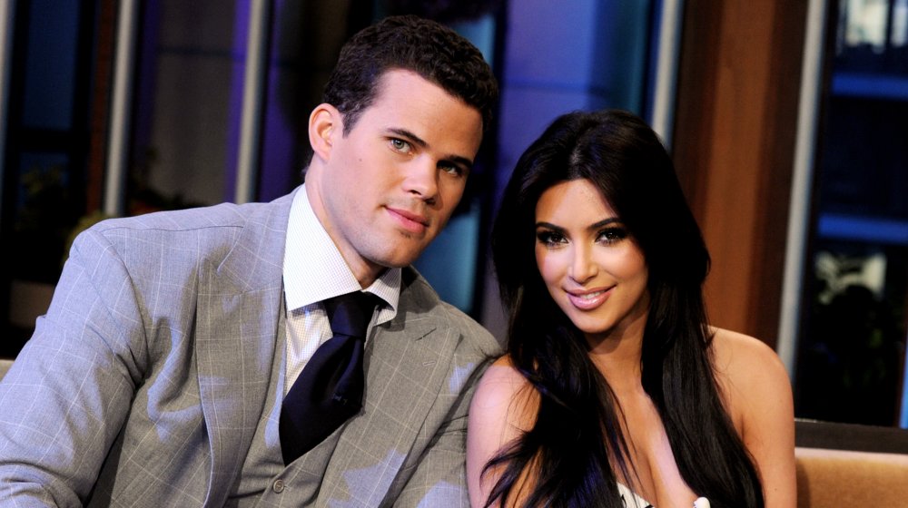 Kris Humphries and Kim Kardashian sitting and smiling